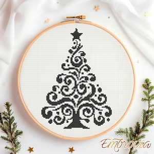May include: A black and white cross-stitch Christmas tree design in a wooden embroidery hoop. The tree features a star on top and decorative swirls. The design is on white fabric, with the word "Embrovia" in gold script.