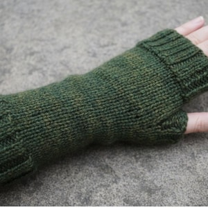 May include: A green knitted fingerless glove. The glove is a dark green colour with subtle variations in the yarn. The cuff and thumb opening are clearly defined. The glove is designed to keep the hand warm while leaving the fingers free.