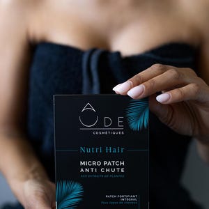 Peut inclure: Une boîte noire avec un motif de feuille tropicale bleue et verte. La boîte contient un produit de soin des cheveux appelé "Nutri Hair Micro Patch Anti Chute Aux Extraits de Plantes". Le texte sur la boîte indique également "Patch Fortifiant Integral Tous types de cheveux" et "Integral Fortifying Patch All hair types".