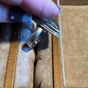 May include: A silver ring with a textured band and the inscription "925" on the inside.