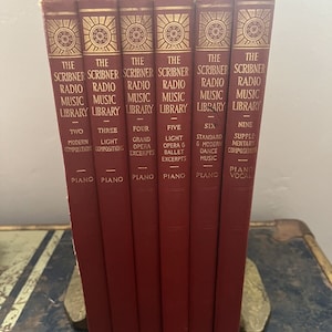 May include: A set of nine red hardcover books with gold lettering. The books are titled "The Scribner Radio Music Library" and each book has a number and a sub-title. The books are arranged in order from left to right.