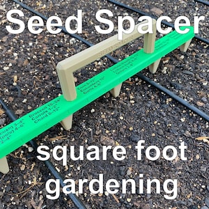 May include: A green and beige seed spacer tool for square foot gardening. The tool has a handle and several prongs, with measurements for various vegetables like broccoli, carrots, and chard. The text "Seed Spacer" and "square foot gardening" are also visible.