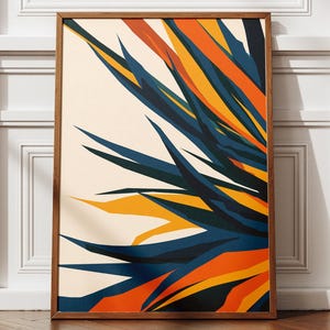 Peut inclure: Une affiche encadrée présentant un motif abstrait de formes superposées dans des tons de bleu, orange et jaune sur fond crème. L'œuvre est posée sur un sol en bois, adossée à un mur blanc.