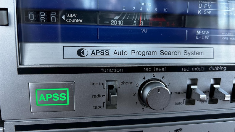 Pu&ograve; includere: Un pannello di controllo audio argentato con display blu, contanastri e VU meter. Include un pulsante APSS illuminato in verde, un selettore di funzione, una manopola per il livello di registrazione e vari interruttori a levetta.
