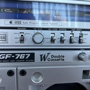 Pu&ograve; includere: Un registratore radio a cassette stereo a 4 bande GF-767 color argento con doppia piastra. Il pannello frontale presenta un sistema di ricerca automatica dei programmi APSS, un display di sintonizzazione, una manopola di registrazione e interruttori.