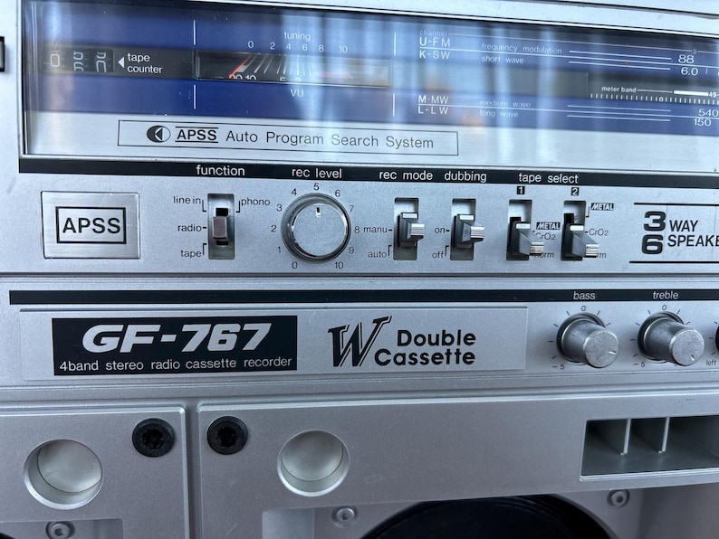 Pu&ograve; includere: Un registratore radio a cassette stereo a 4 bande GF-767 color argento con doppia piastra. Il pannello frontale presenta un sistema di ricerca automatica dei programmi APSS, un display di sintonizzazione, una manopola di registrazione e interruttori.