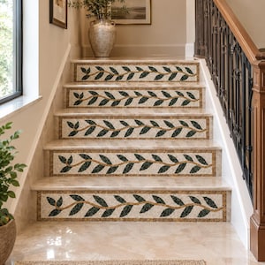 May include: A set of five staircase risers featuring a decorative horizontal vine pattern. Each riser displays a repeating motif of dark green leaves on a thin brown stem, set against a speckled beige background with a gold-toned border.