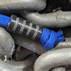 Cordón de micarta negro mediano con cuatro ranuras y un cordón Paracord gratis