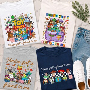 Puede incluir: Cuatro camisetas con gráficos de Toy Story 5, varias ilustraciones de personajes y el texto You've got a friend in me. Las camisetas son blancas, crema, grises y azul marino, junto a vaqueros azules y zapatillas blancas.