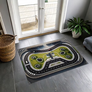 Könnte beinhalten: Ein schwarz-weißer Rennstrecken-Teppich mit grünem Gras und einem roten Auto. Der Teppich ist so gestaltet, dass er wie eine echte Rennstrecke mit Kurven und Geraden aussieht.