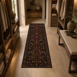 May include: A long, rectangular runner rug featuring a dark black background with an intricate, symmetrical floral pattern in shades of deep red, gold, and cream. The design includes elaborate botanical motifs and a decorative border.