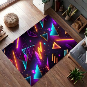 Puede incluir: Una alfombra colorida con un patrón geométrico de triángulos de color rosa neón, azul y amarillo sobre un fondo morado oscuro. La alfombra tiene un diseño moderno y abstracto.