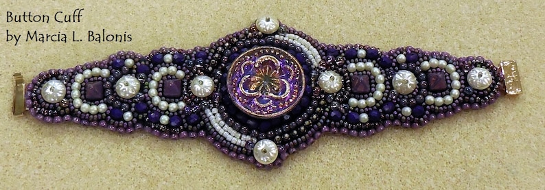 May include: A purple and white beaded bracelet with a large, purple button in the center. The button has a flower design and is surrounded by smaller beads. The bracelet is made by Marcia L. Balonis.