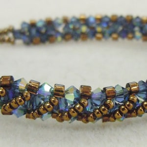 May include: A blue and copper beaded bracelet with a woven pattern.