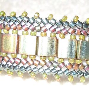 Könnte beinhalten: Ein mehrfarbiges Perlenarmband mit einer Reihe goldfarbener Metallquadrate in der Mitte.