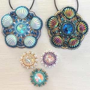 May include: Handmade beaded seashell pendants and brooches in shades of blue, teal, gold, and iridescent colors. The pendants feature large, detailed seashell designs with central crystal accents. The brooches are smaller, round, and also feature crystal and bead embellishments.