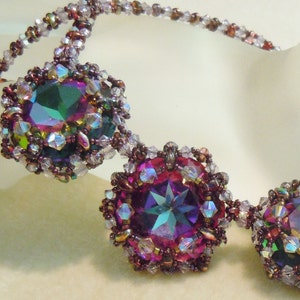 Può includere: Una collana di perline con tre grandi pietre preziose iridescenti in tonalità di verde, viola e rosa. Le pietre preziose sono circondate da perline più piccole in tonalità di marrone e bianco.