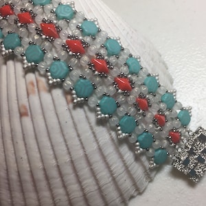 May include: A multi-strand beaded bracelet featuring turquoise, white and red beads. The bracelet has a silver clasp.