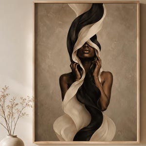 Peut inclure: Une &oelig;uvre encadr&eacute;e repr&eacute;sente une femme &agrave; la peau fonc&eacute;e, le visage partiellement dissimul&eacute; par un tissu fluide noir et cr&egrave;me. L'&oelig;uvre est expos&eacute;e dans une pi&egrave;ce aux tons neutres, avec un meuble beige et un vase avec des branches s&eacute;ch&eacute;es.