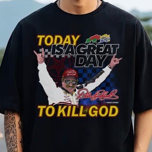 May include: Black graphic t-shirt with the text "TODAY IS A GREAT DAY TO KILL GOD". The shirt features a graphic of a man with his arms raised, wearing a racing suit and sunglasses. The design includes a checkered flag and other racing-themed elements.