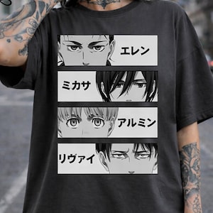 May include: Dark gray t-shirt featuring four panels with anime character eyes and names in Japanese. The top panel reads "Eren", followed by "Mikasa", "Armin", and "Rivai". The design is in black and white.