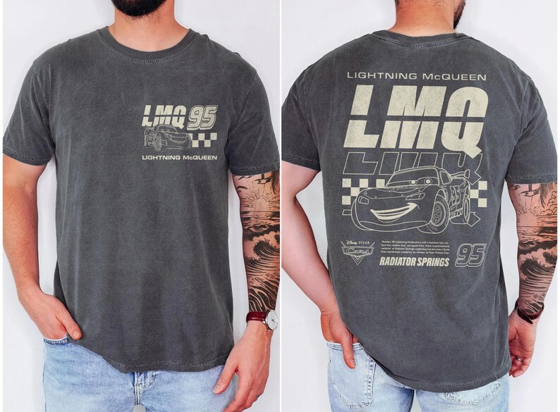 Puede incluir: Camiseta gris oscuro con Lightning McQueen de la pel&iacute;cula Cars. La parte delantera muestra "LMO 95" con un gr&aacute;fico de coche y "Lightning McQueen". La parte trasera tiene un dise&ntilde;o m&aacute;s grande con el coche, "95" y "Radiator Springs."