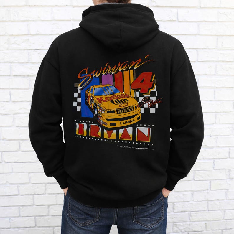 May include: Black hooded sweatshirt with a colorful graphic on the back. The graphic features a yellow race car with "Kodak Film" on it, the number "4", and the name "Swirvan". The word "IRMAN" is also displayed.