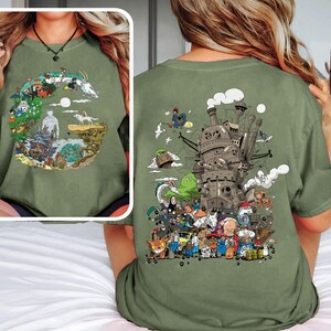 Op de afbeelding: Olijfgroen T-shirt met een kleurrijke afbeelding uit een populaire animatiefilm. Het ontwerp bevat een kasteel, personages en elementen uit de film. Het shirt is een comfortabele, casual stijl.