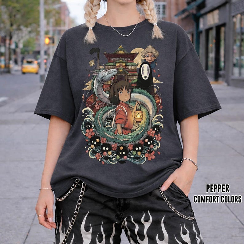 May include: Dark grey t-shirt with a vibrant anime-style illustration. The design showcases a girl with a lantern, a dragon, and other characters. The text "PEPPER COMFORT COLORS" is printed on the lower right.