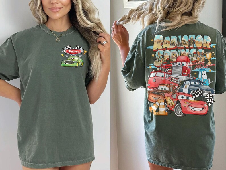 May include: Dark green t-shirt with a front graphic of a green race car and the name "Name", and a back graphic of cartoon cars with the text "Radiator Springs". The shirt has short sleeves and a loose fit.