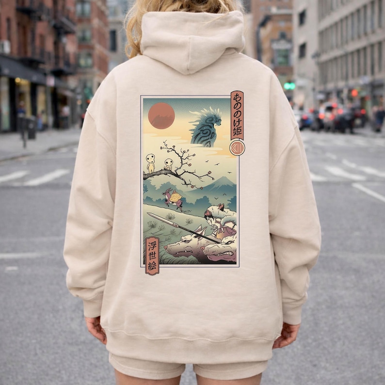 May include: Beige hoodie featuring a Japanese anime-style illustration on the back. The artwork depicts a landscape with figures, a red sun, and Japanese text. The hoodie has a hood and a relaxed fit.