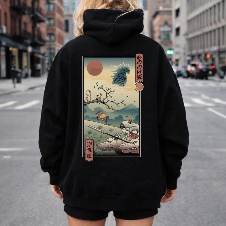 May include: Black hoodie featuring a Japanese anime-style illustration on the back. The artwork depicts a scene with characters, a red sun, and Japanese text. The hoodie has a drawstring hood and a kangaroo pocket.