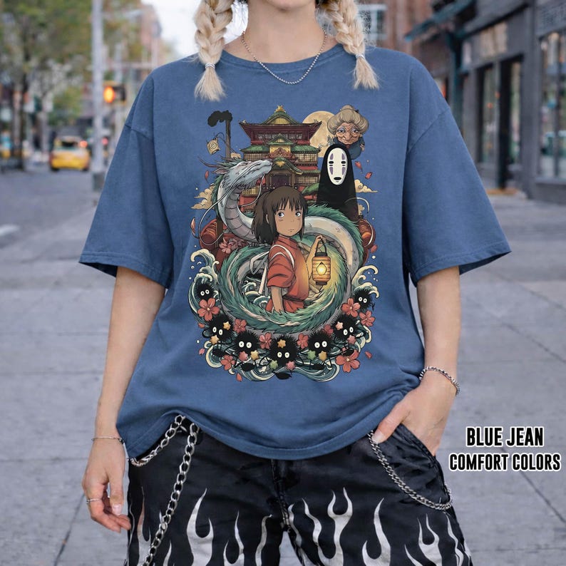 May include: Blue jean coloured t-shirt featuring a graphic from a Japanese animated film. The graphic shows a girl with a lantern, a dragon, and other characters. The text "BLUE JEAN COMFORT COLORS" is printed on the bottom right.