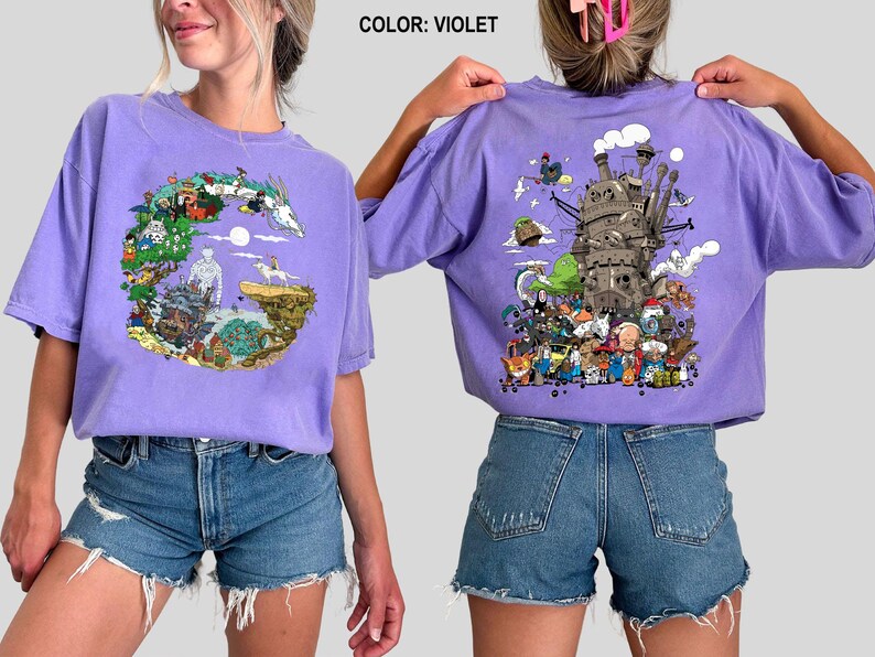 Op de afbeelding: Violet T-shirt met korte mouwen met een kleurrijk grafisch ontwerp op de voor- en achterkant. Het ontwerp aan de voorkant is een cirkelvormige illustratie met personages en landschappen. Het ontwerp aan de achterkant toont een gedetailleerde illustratie van een kasteel en personages.