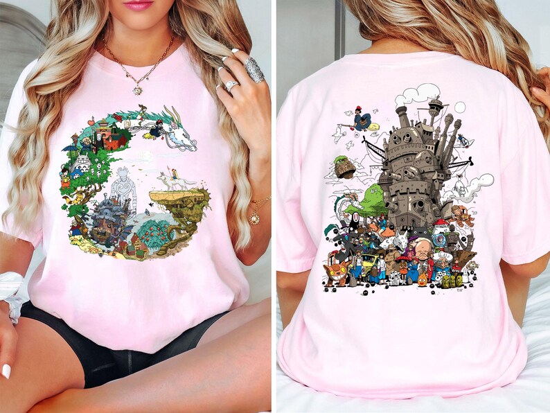 Op de afbeelding: Lichtroze t-shirt met een kleurrijk grafisch ontwerp uit een populaire animatiefilm. Het ontwerp aan de voorkant is een cirkelvormige opstelling van personages en landschappen. De achterkant van het shirt toont een gedetailleerde illustratie van een kasteel en verschillende personages.