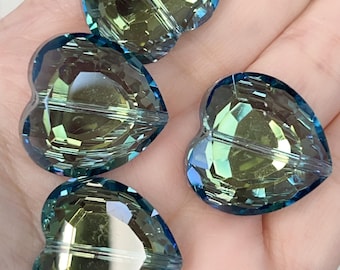 Puede incluir: Cuatro cuentas en forma de corazón con un diseño facetado. Las cuentas tienen un esquema de color degradado, que pasa de un azul verdoso a un tono amarillo verdoso. Las cuentas están hechas de un material transparente y reflectante.