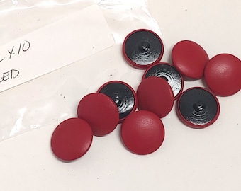 Könnte beinhalten: Eine Tüte mit 10 roten Knöpfen mit schwarzen Mittelpunkten. Die Tüte hat ein Etikett mit der Aufschrift "40L x 10 ROT".