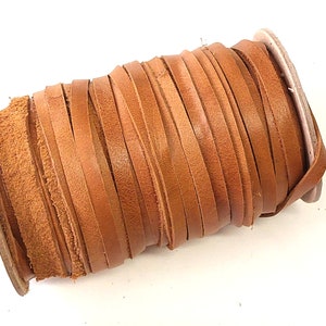 May include: A spool of brown leather cord, wound tightly and ready for crafting projects.