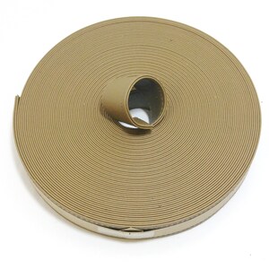 May include: A roll of tan colored webbing, rolled up and tied with a piece of the same webbing.