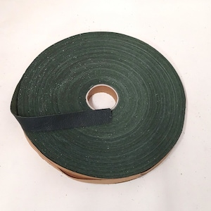 May include: A roll of dark green fabric tape with a brown cardboard core.