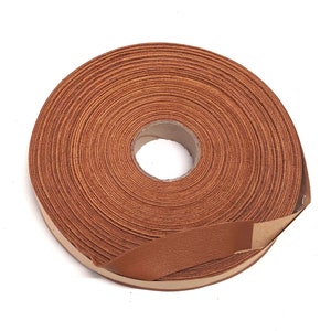 May include: A roll of brown leather cord, wound tightly and ready to be used for crafting projects.