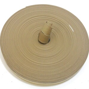 May include: A roll of tan leather strap, coiled and ready to be used for crafting projects.
