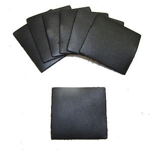 Puede incluir: Un conjunto de ocho cuadrados de cuero negro. Los cuadrados miden aproximadamente 5 cm por 5 cm.