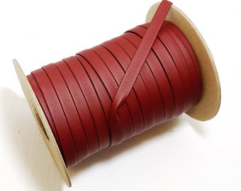 Può includere: Un rotolo di cordoncino in pelle rossa, avvolto attorno a un nucleo di cartone. Il cordoncino è largo circa 6 mm.