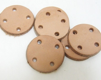 May include: Six round, light brown leather discs with five holes each. The discs are stacked on top of each other.