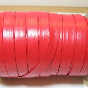 May include: A spool of bright red leather cord, wound around a cardboard core.