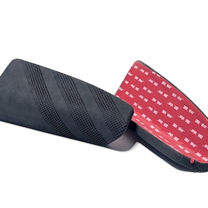 May include: Two black, curved automotive accessories. One has a perforated surface, the other has a red adhesive backing with white text. The accessories are designed to be attached to a vehicle.