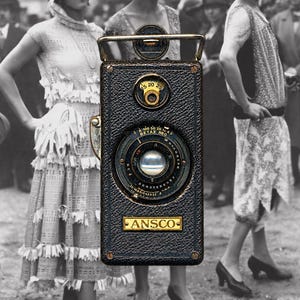 May include: A vintage black Ansco box camera with a textured leather-like finish, a central lens, and a metal top handle. The camera features a circular dial with numbers 15, 20, 25 and a lens marked Betax No. 1. The Ansco brand name is printed on a gold-toned rectangular plate.