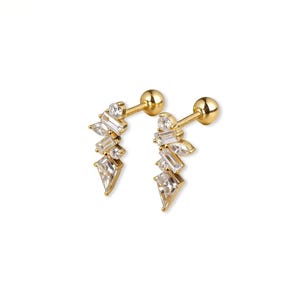 May include: A pair of gold-coloured stud earrings. Each earring features a cluster of clear, sparkling gemstones in various shapes, including baguette and teardrop cuts. The earrings have a post and ball closure.