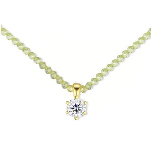 Può includere: Una collana con una singola pietra preziosa trasparente a taglio brillante rotondo incastonata in un pendente in oro giallo a sei griffe, sospesa a un filo di piccole perle sfaccettate verde chiaro che conferiscono un aspetto delicato.